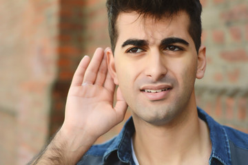 young man listening something. Outdoors.