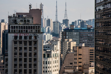 Skyline of a concrete megalopolis with abandoned buildings painted with graffiti and television antennas on the background.