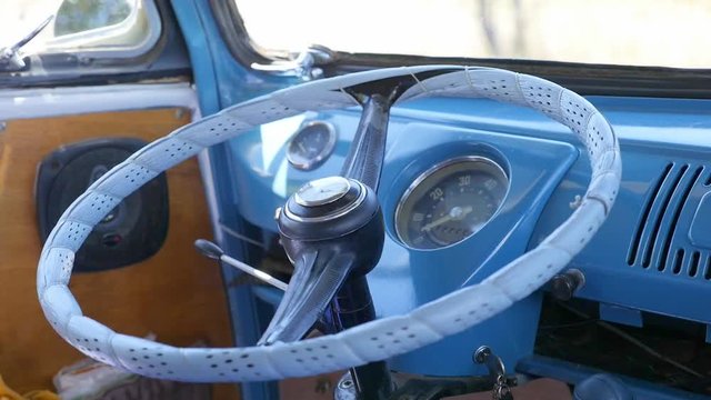 a blue camper van interior steering wheel sitting in a field.