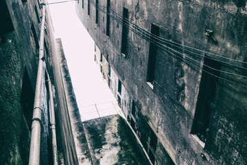 Cracked concrete walls of an worn abandoned building used as home from poor people.
