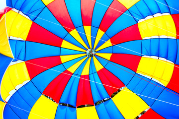 Falling open color parachute Bright background