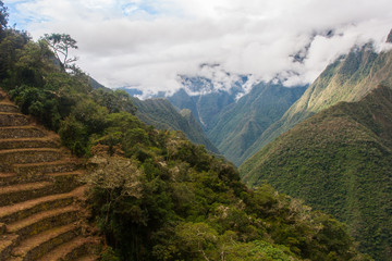 Landscape view of ancient Inca agriculture terrace with mountains and clouds on the background. Machu Picchu. Peru. South America. No people.