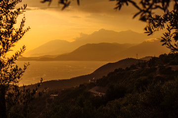 Fototapeta premium Beautiful view from the hill overlooking the sea and mountains, Albania, the Ionian Sea. Sunset