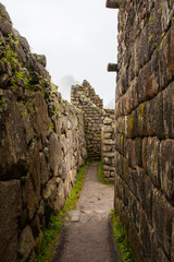 Fototapeta na wymiar Vertical image of a stone corridor on the ancient Machu Picchu lost city in the Andes. Peru, South America, no people.