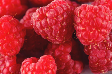 Raspberry on a background of gray cement. Ripe and juicy fresh raspberries. A lot of berries close-up.