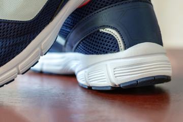 Running shoes are blue with white soles in the gym
