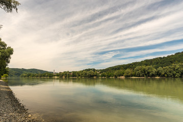 Beautiful landscape with a small church and Danube river at sunset in Wachau, Austria