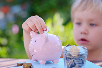 Piggy bank and little boy with coin on colorful background, close up