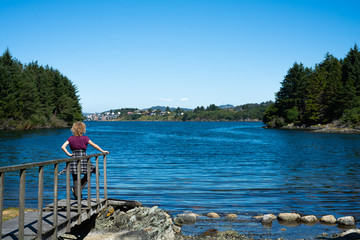Girl watching over a lake in norway near haugesund