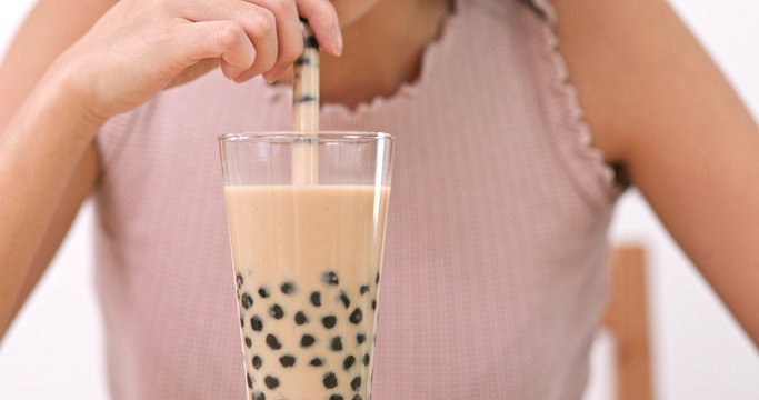 Woman enjoy Glass of Taiwan Bubble milk tea