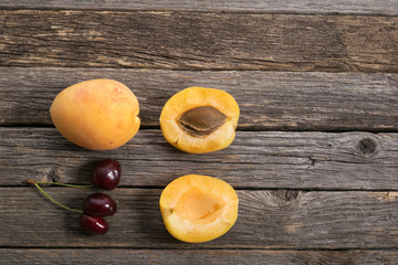 Cherries and apricot on a wooden table. View from the above