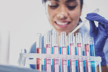 Dark-haired biologist. Dark-haired professional biologist feeling very busy while looking at test...