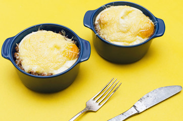 Buckwheat porridge with cheese and egg on yellow background. Healthy food.