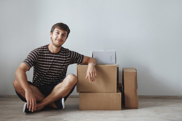 Young cute guy sits on the floor