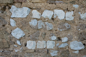 Beautiful wallpaper background of an antique wall made of square stone white bricks whit cement. No people.