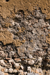 Vertical image of an old cracked concrete and brick wall. Beautiful rough texture. No people.