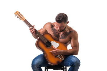 Portrait of muscular man with tattoo playing guitar. Isolated on white background