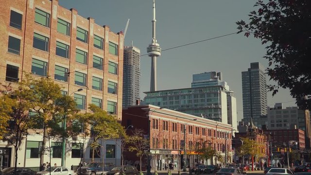 Slow motion shot tilting up with the CN Tower standing over the city of Toronto