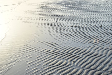 Wellenförmiger Sand am Strand nach Ebbe am Morgen