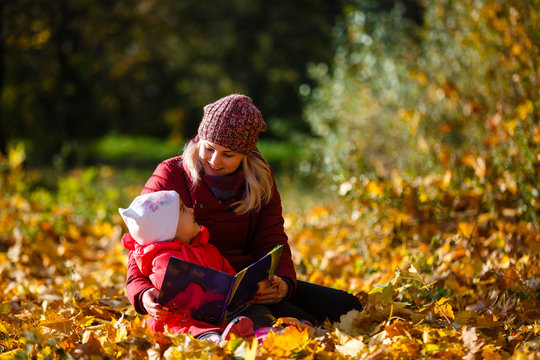 Mother daughter time. Soft focus shot of a mother and daughter reading a book together relaxing near the autumn park