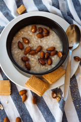 Oatmeal with hazelnuts and boiling on a white table