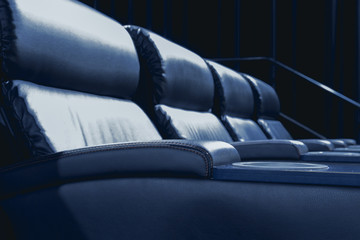 Empty modern cinema with recliner leather seat.