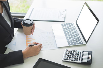 business woman with laptop, Business team working on a new business plan with modern digital computer, finance graph and writes on a document at her office