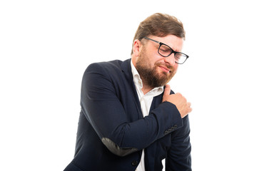 Portrait of business man showing shoulder pain gesture.