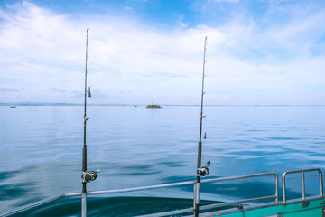 Fishing rods on a charter boat on calm, tranquil sea in Far North District, Northland, New Zealand,...