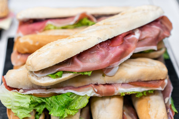 Ham and cheese baguette. Hot pastries lie on the shelf in the cafe. Buns and bagels in the store.