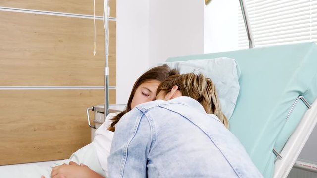 Mother sleeping in hospital bed next to her sick daughter. Healthcare and medicine