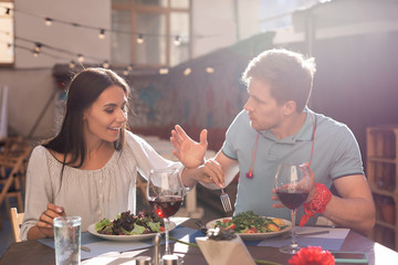 Fork in plate. Appealing woman putting her fork in boyfriend plate while wanting trying his delicious dish