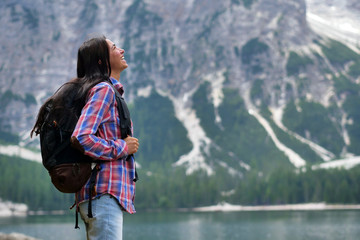 Portrait of a beautiful woman (girl) while she is looking at the mountains. Concept: Holiday, travel, happiness, freedom