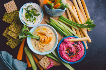 Fresh vegetarian dips in small bowls on table