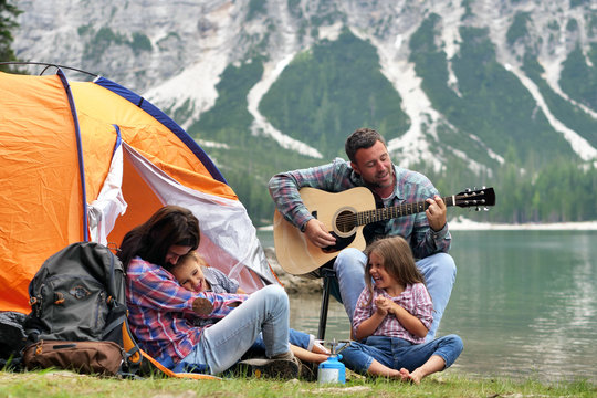 Portrait Of A Happy Family While They Are Having A Good Day At The Lake. Concept: Love, Holiday, Music