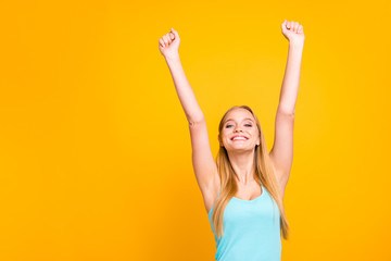 Happy young girl in blue t-shirt raised her hands up and looked happy at the camera high held head...