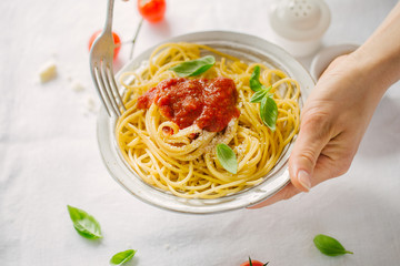 Serving pasta dish with tomato sauce on white