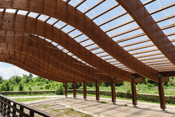 massive wood beams roof structure with S curved shaped and covered with transparent polycarbonate...