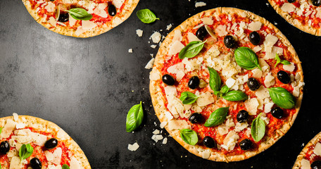 Traditional italian pizzas on dark table