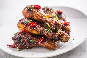 Grilled roasted and barbecue chicken legs on white plate