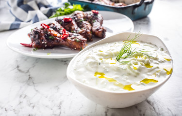 Greek dip sauce or dressing tzatziki with chicken legs