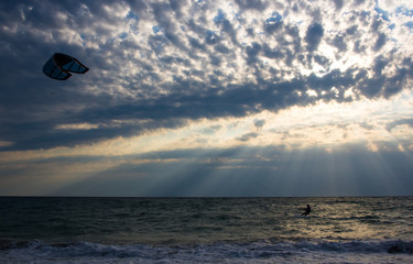 kitesurfer rides a kite-surf on waves of the sea
