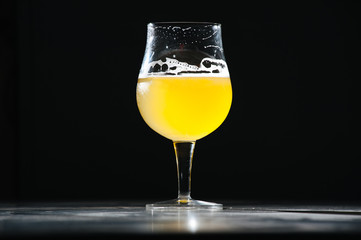 Glass beer with foam on black background with copyspace