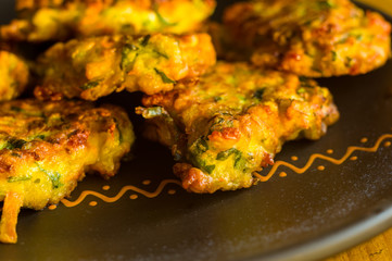 Fried vegetable fritters with zucchini, carrots, herbs, eggs, and cheese.