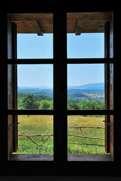 nature landscape with a view through a   wooden frame window