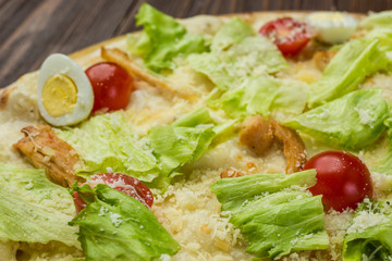 Pizza Caesar with chicken and tomatoes on wooden background
