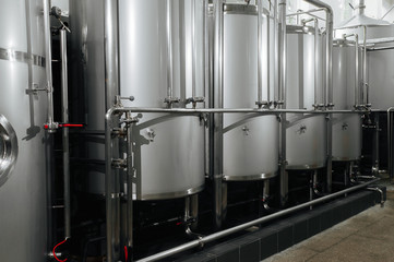 Craft beer brewery equipment. Modern beer plant with brewering kettles, tubesmade of stainless steel for alcoholic drink production.