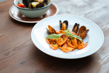Pasta with seafood. Nice delicious dish with Italian pasta and tasty seafood in tomato sauce lying in white plate
