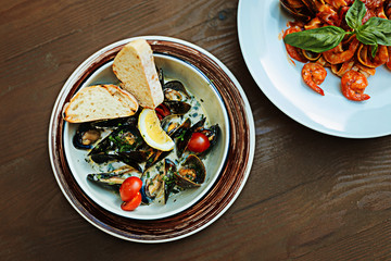 Yummy dishes. Top view of nice yummy seafood dishes standing on the wooden table on summer terrace