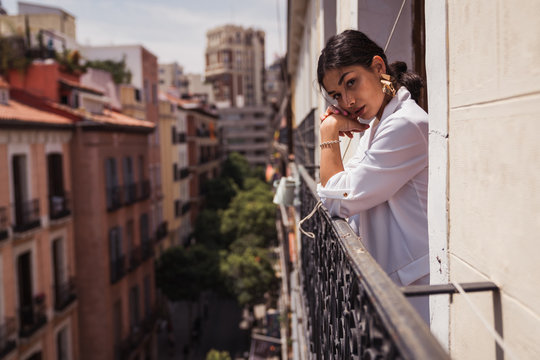 Alluring elegant woman leaning on fence